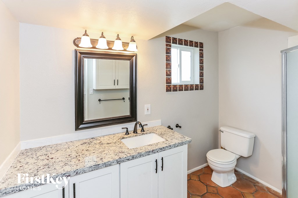 a bathroom with a sink toilet and a mirror