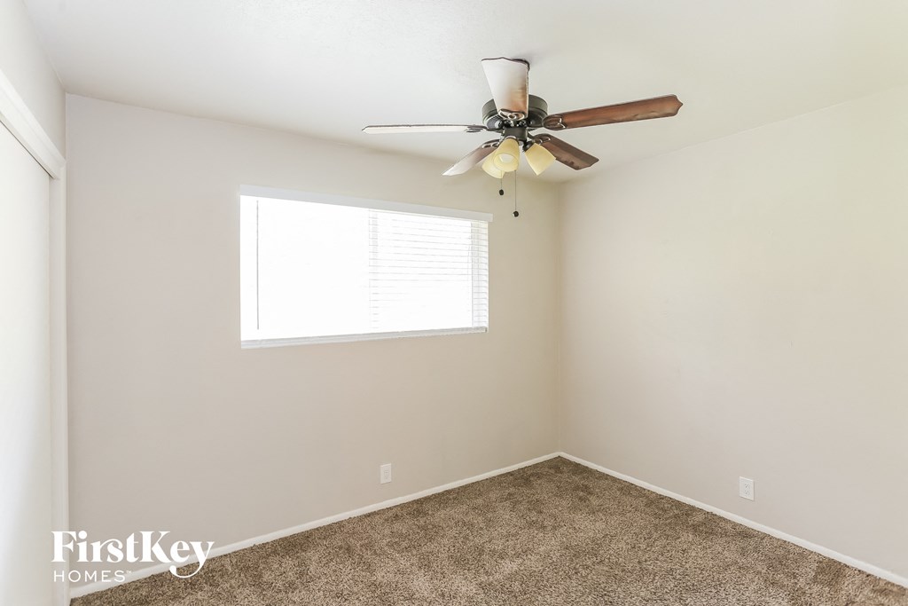 a bedroom with a ceiling fan and a window