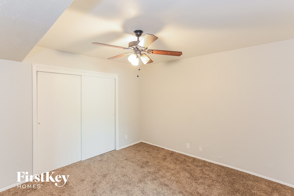 a bedroom with a ceiling fan and a closet