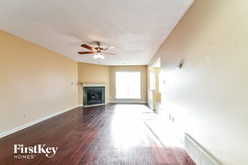 the living room of an empty house with a ceiling fan