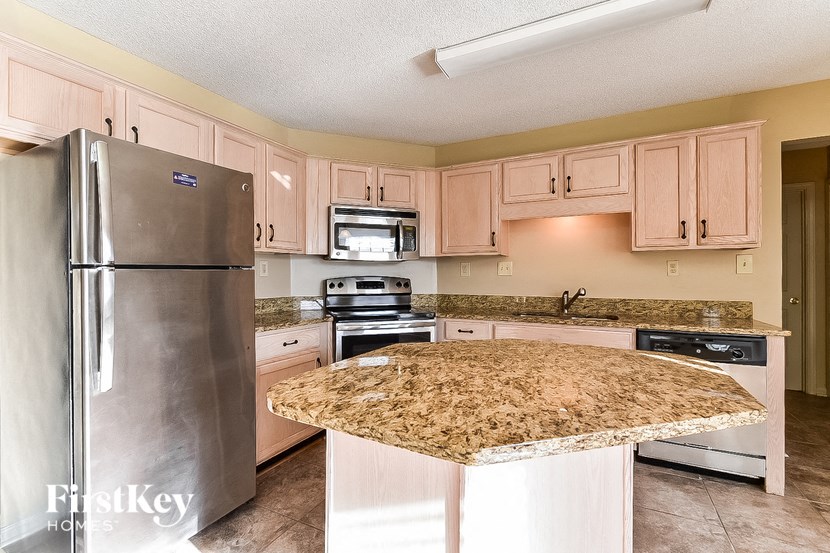 a kitchen with white cabinets and a granite counter top