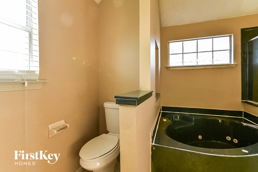 a bathroom with a toilet and a bath tub and a sink