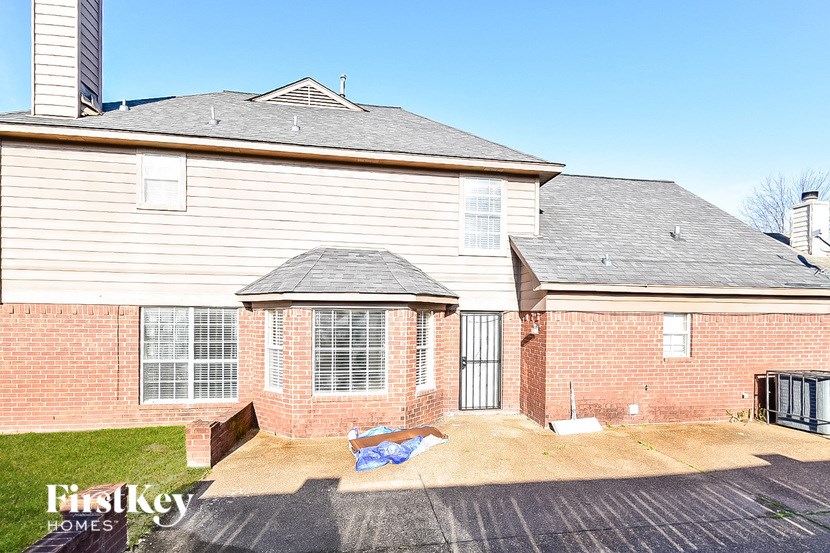 a white house with a brick wall and a garage
