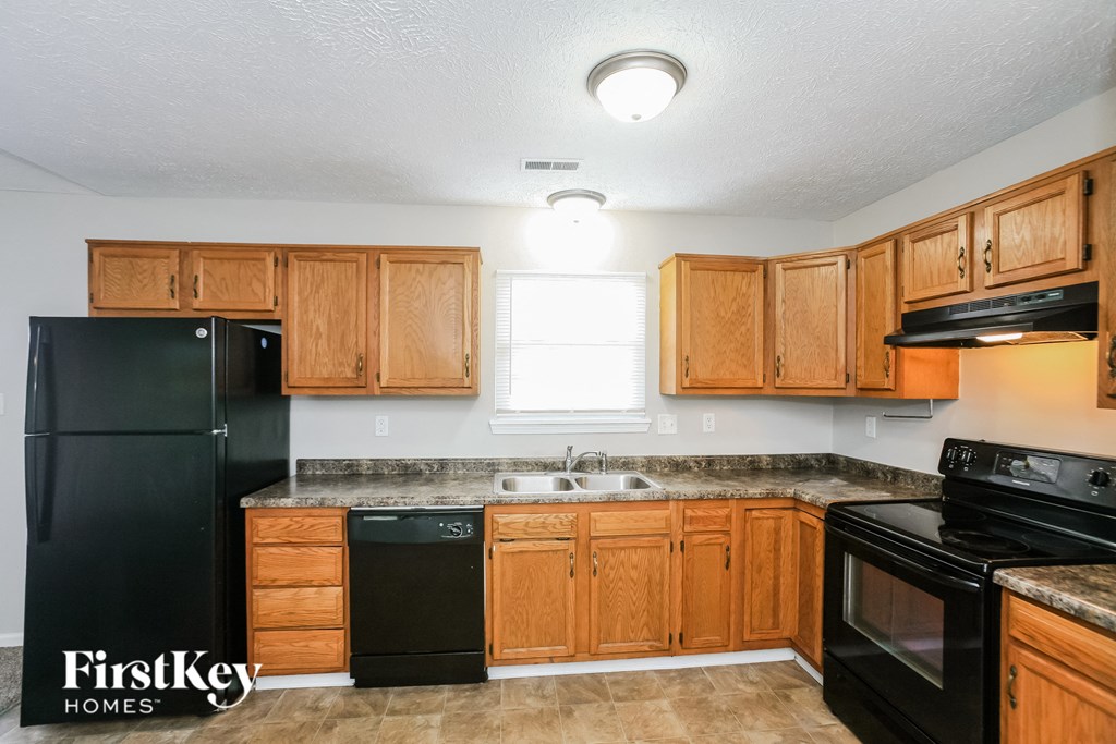 a kitchen with black appliances and wooden cabinets