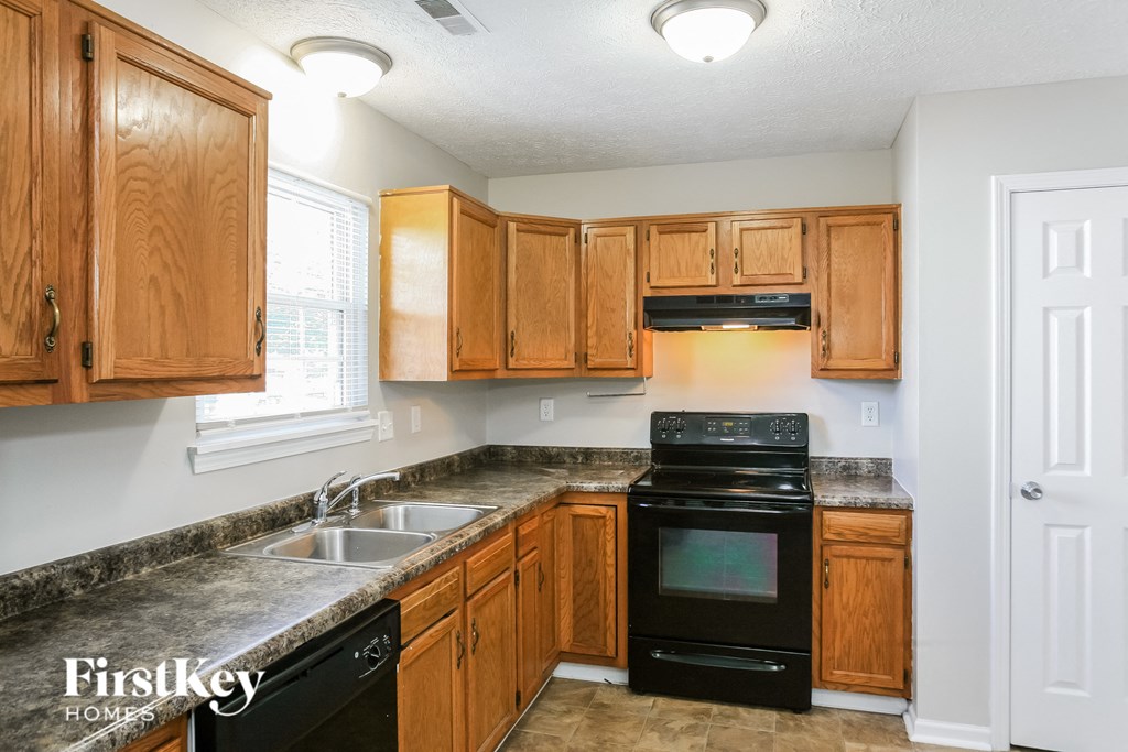 a kitchen with wooden cabinets and black appliances