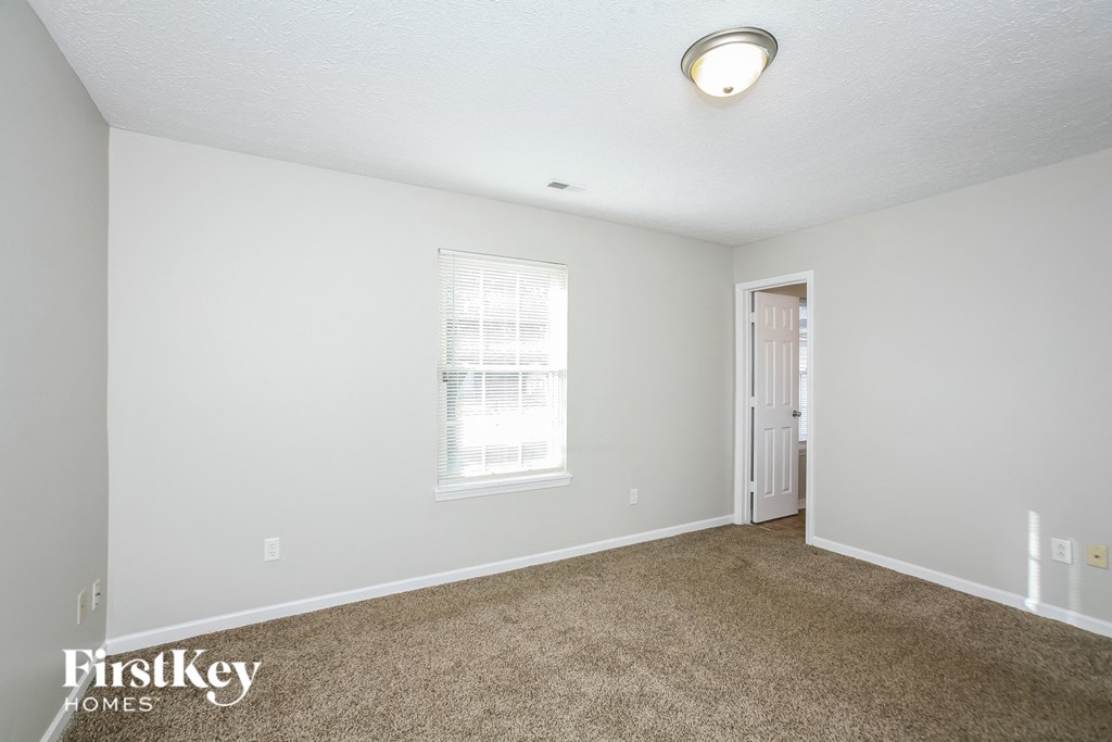 a bedroom with a carpeted floor and a white door