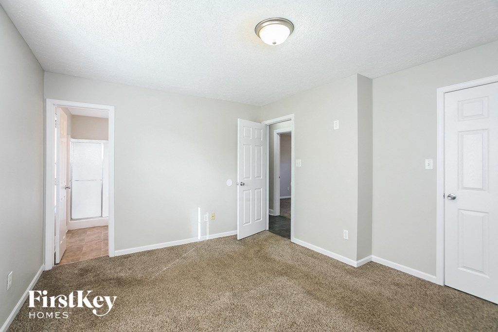 a spacious living room with carpet and white walls