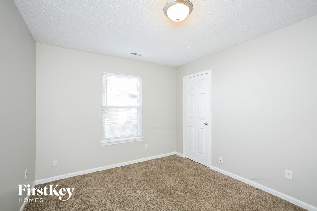 a bedroom with a carpeted floor and a white door