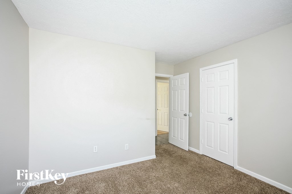 a bedroom with a closet and a door to a hallway