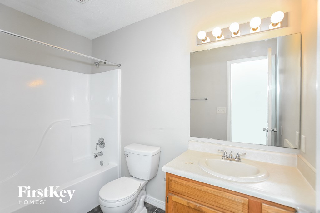 a bathroom with a sink toilet and a mirror
