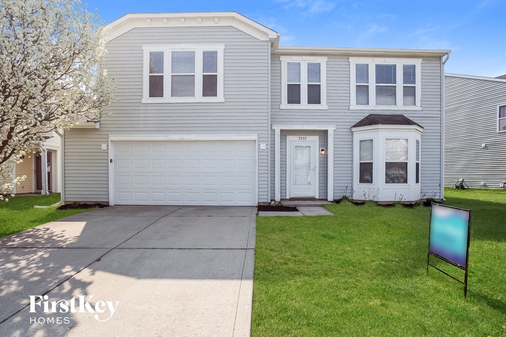 A two-story house with a garage and a sign that says "Firstkey Homes".