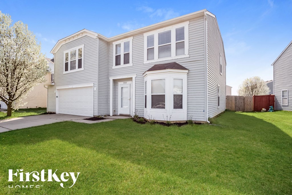 A two-story house with a garage is for sale.