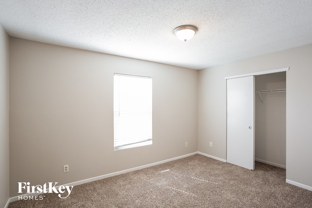 A room with a carpeted floor and a small window.