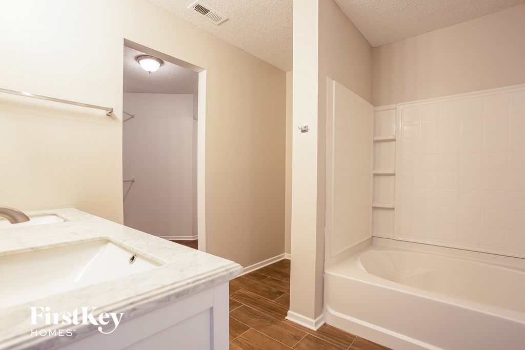 A white bathroom with a tub and sink.