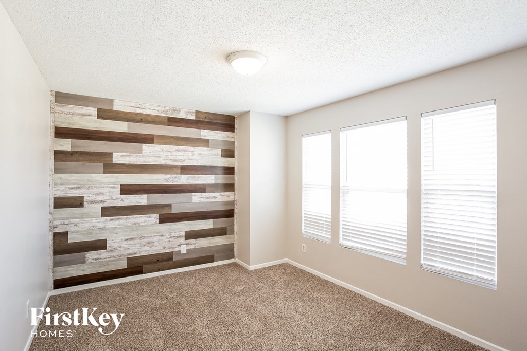 A room with a stone wall and a carpeted floor.