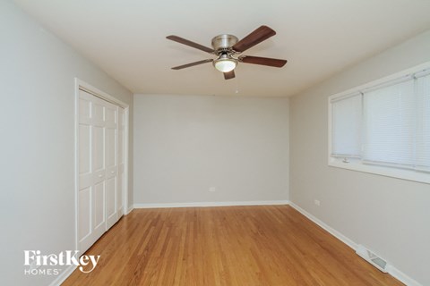 a bedroom with a ceiling fan and wood floors
