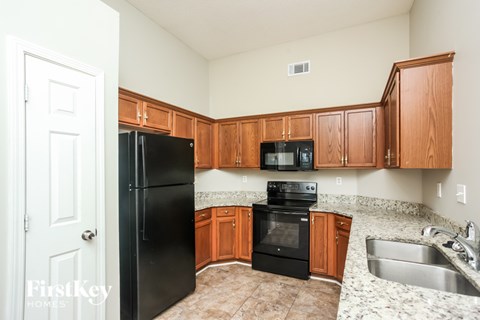 A kitchen with black appliances and wooden cabinets.