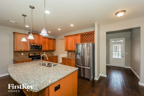kitchen with granite countertops and stainless steel appliances and wood flooring
