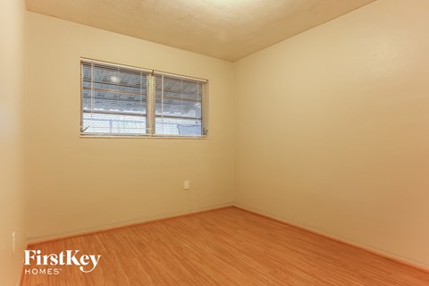 the living room of a house with wood floors and a window