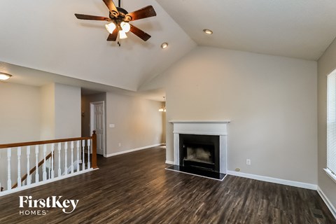 a living room with a fireplace and a ceiling fan