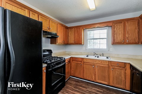a kitchen with wooden cabinets and a black refrigerator