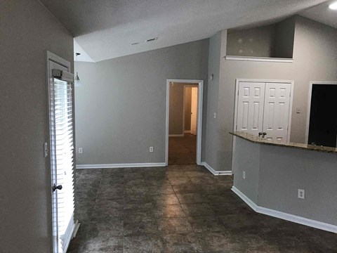 a living room with grey walls and a door to a hallway