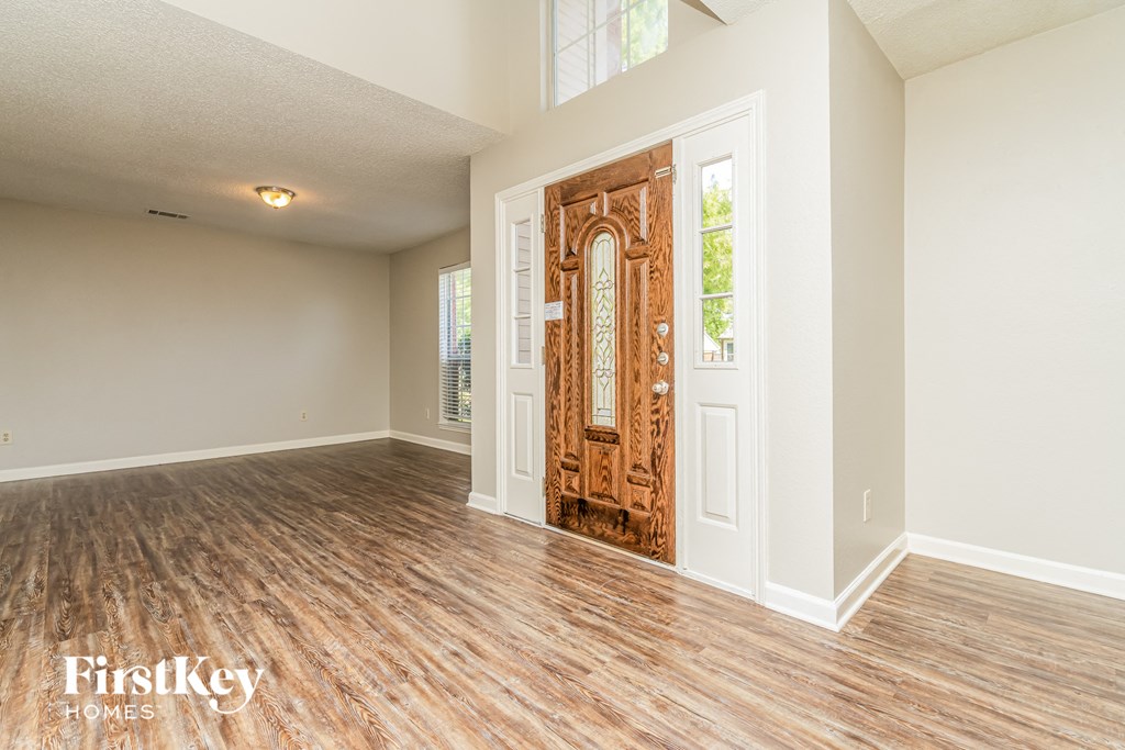the living room of an empty house with a wooden door