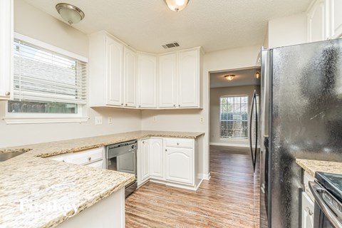 a kitchen with white cabinets and a stainless steel refrigerator