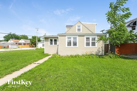 a house with a yard and a sidewalk in front of it