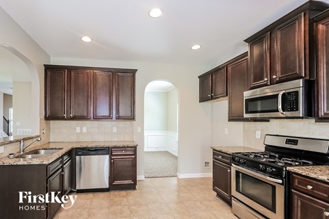 a kitchen with dark wood cabinets and stainless steel appliances