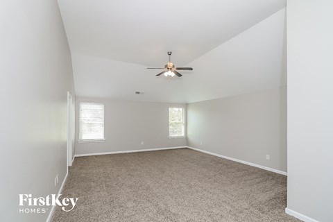 a bedroom with a ceiling fan and a carpet