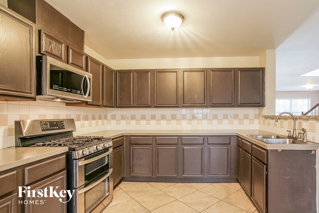 A kitchen with brown cabinets and a stove top oven.
