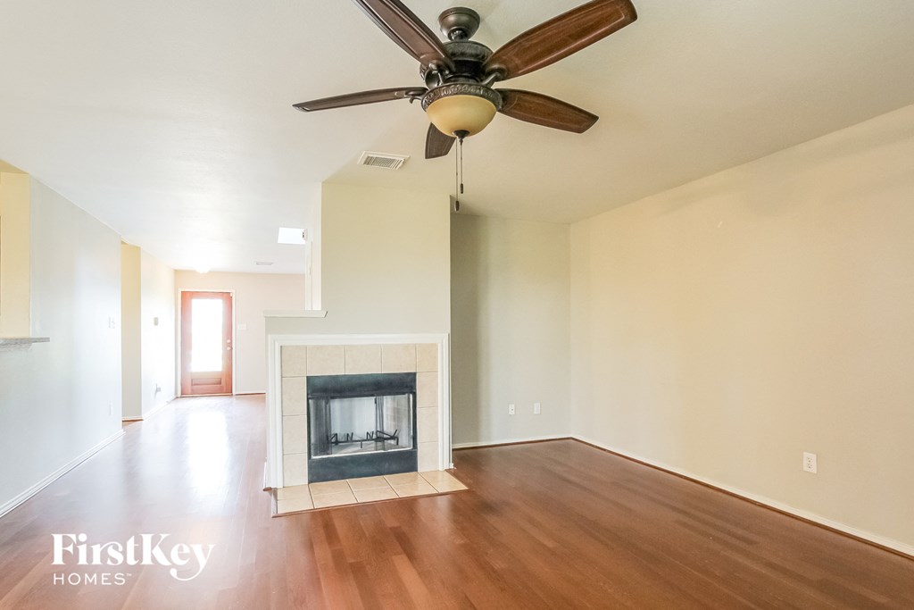 A room with a fireplace and a ceiling fan.