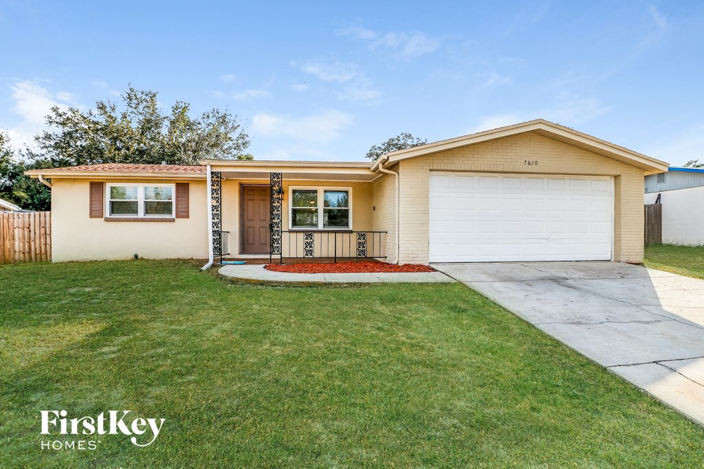 a home with a driveway and lawn in front of it