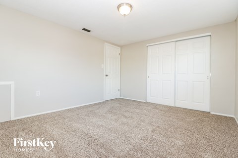 a spacious living room with carpet and white doors