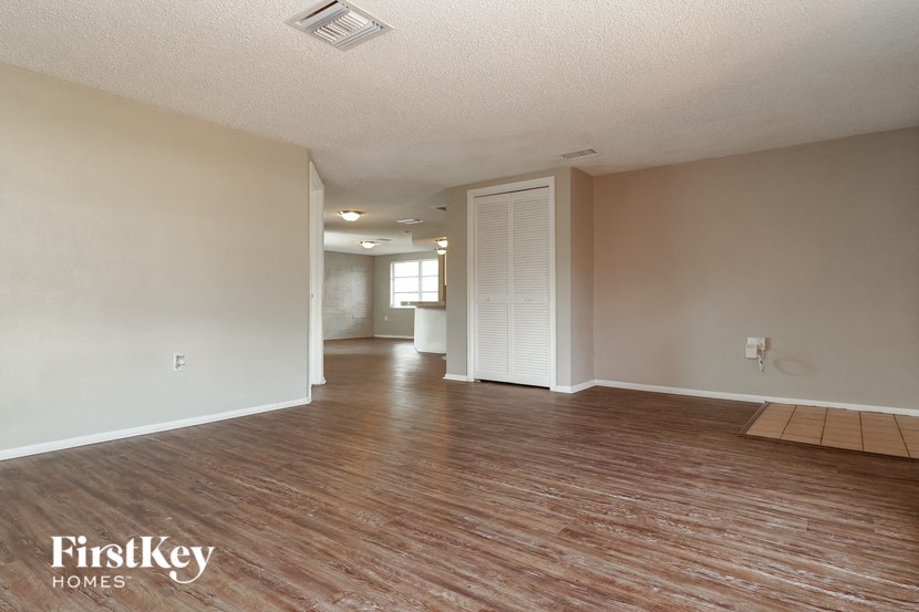 an empty living room and dining room with wood flooring
