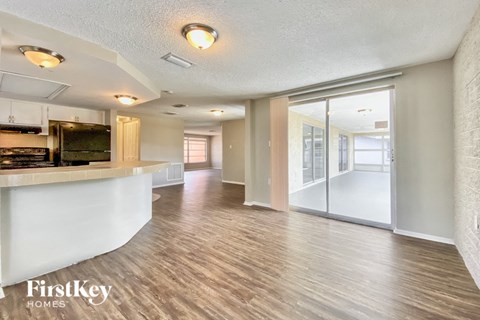 an open kitchen and living room with a large window and a kitchen counter