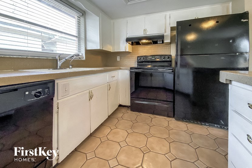 a kitchen with black appliances and white cabinets