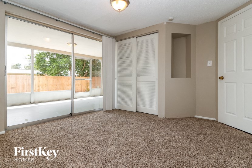 an empty living room with a large window and a door
