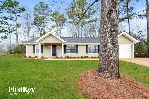 a home with a large tree in the front yard