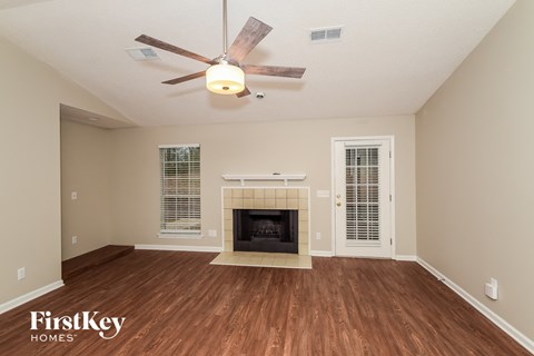 a living room with a fireplace and a ceiling fan