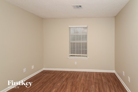 a spacious room with hardwood floors and a window