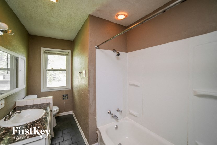 a bathroom with a tub and a sink and a toilet