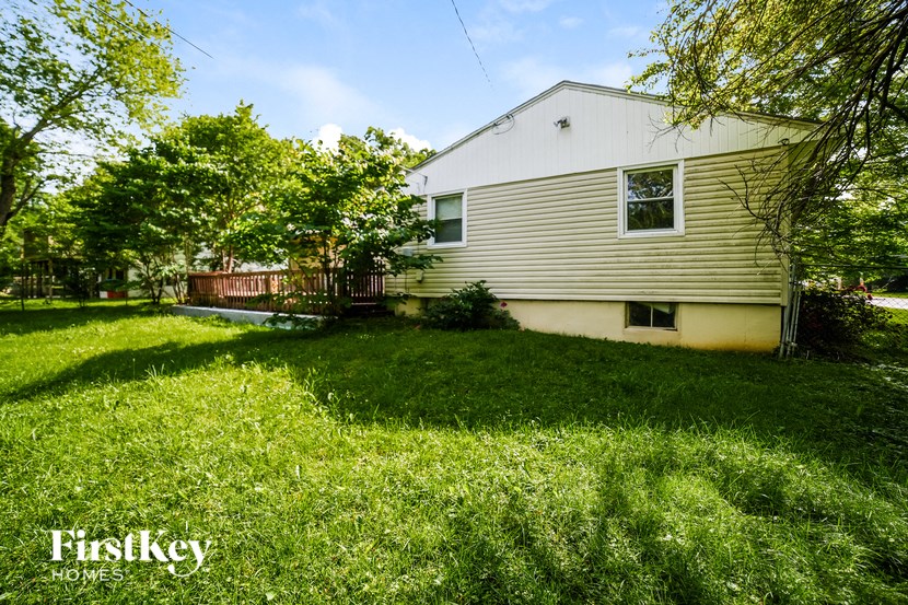 a backyard with a house and a yard with grass and trees