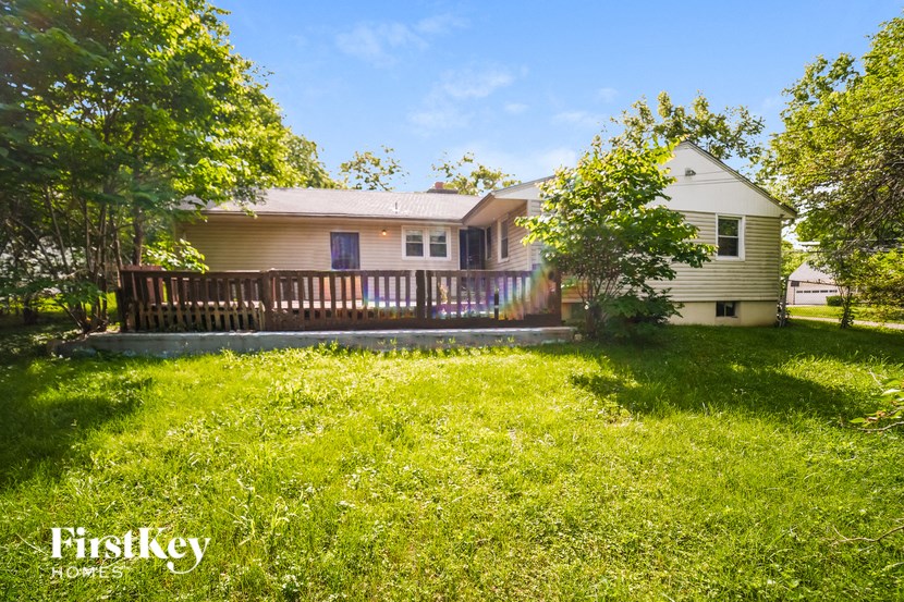 a house with a deck and a yard in front of it