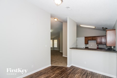 A kitchen area with wooden floors and white walls.