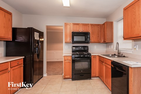 A kitchen with wooden cabinets and black appliances.