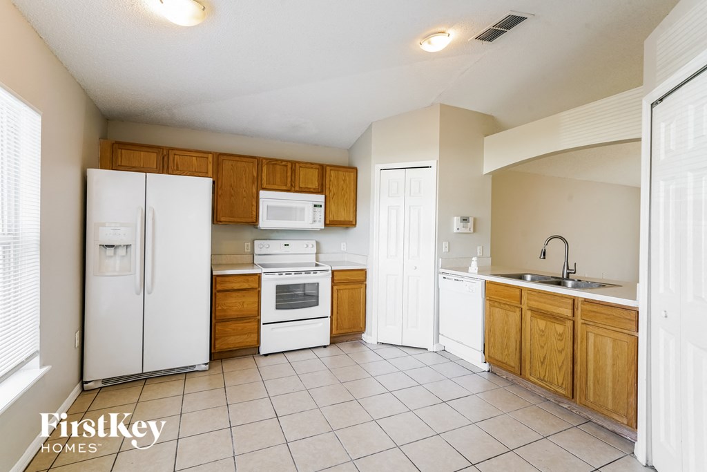 a kitchen with white appliances and wooden cabinets