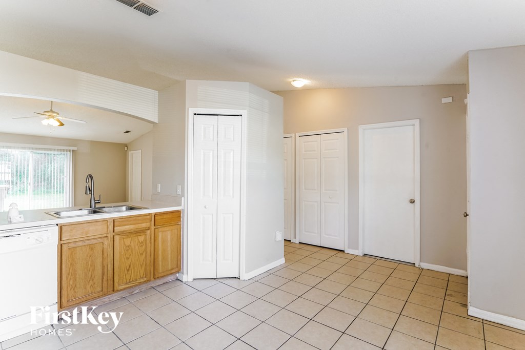 a kitchen with tiled flooring and a sink and two doors