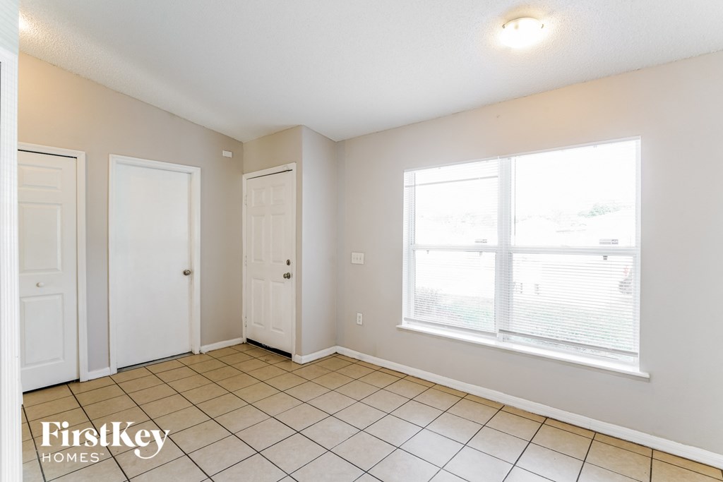 a living room with a large window and a tiled floor